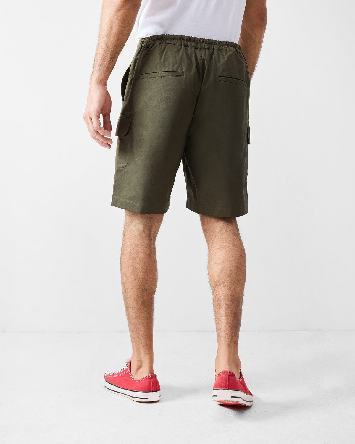 Back of olive utility shorts showing rear pockets and cargo flaps.