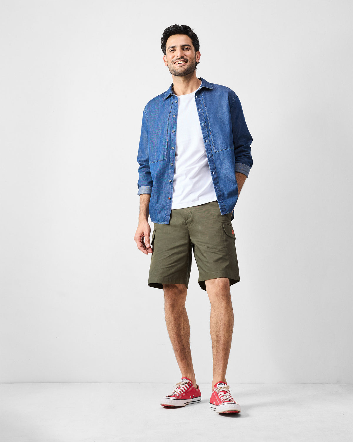 Olive utility shorts worn in a casual layered outfit.