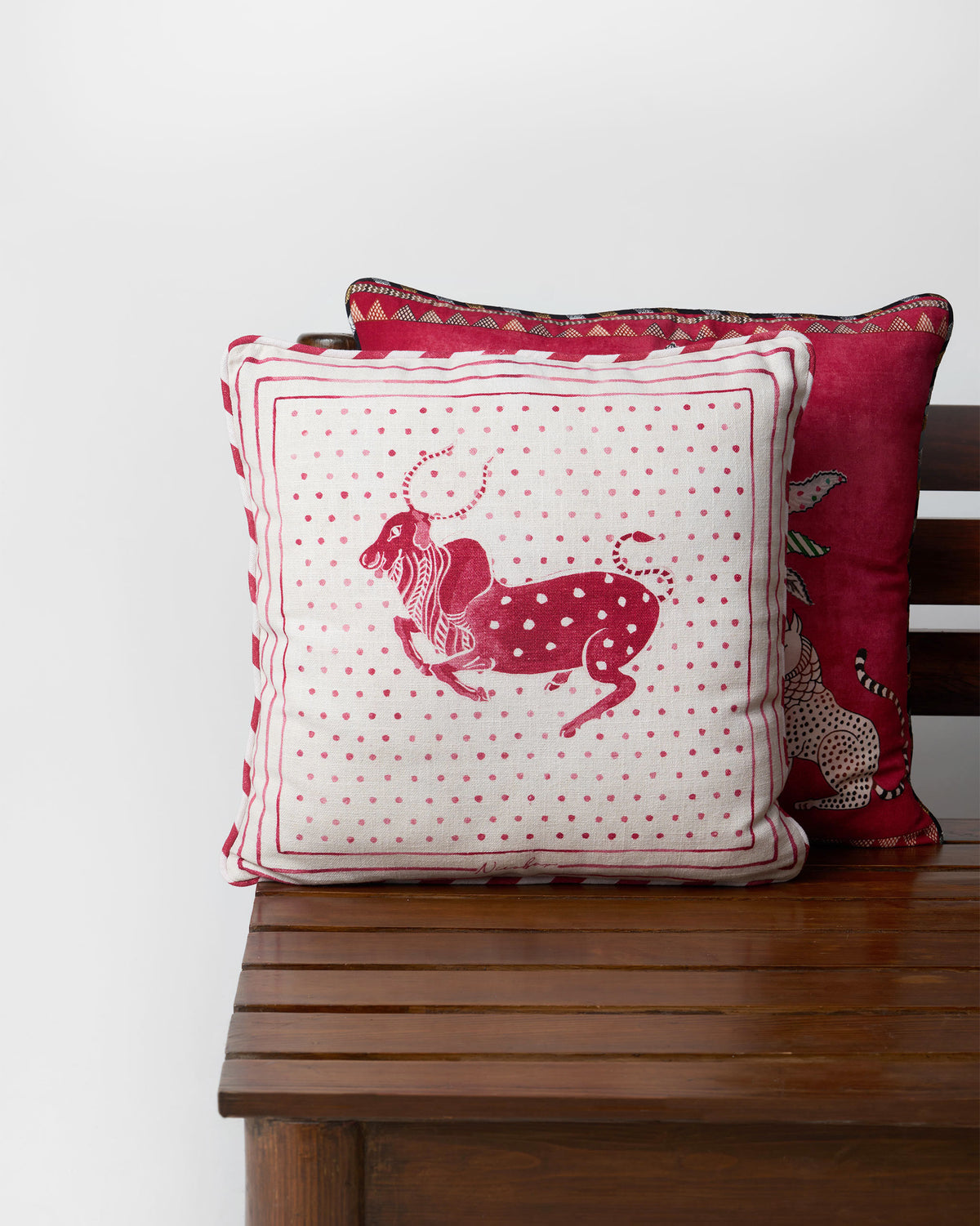 Leaping Bull cushion cover with a red bull motif on white dots.