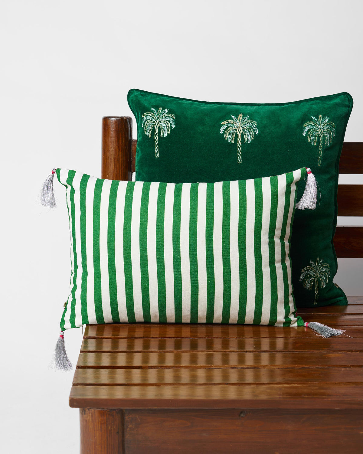 Harappa cushion cover showing a green-and-white striped face with corner tassels.