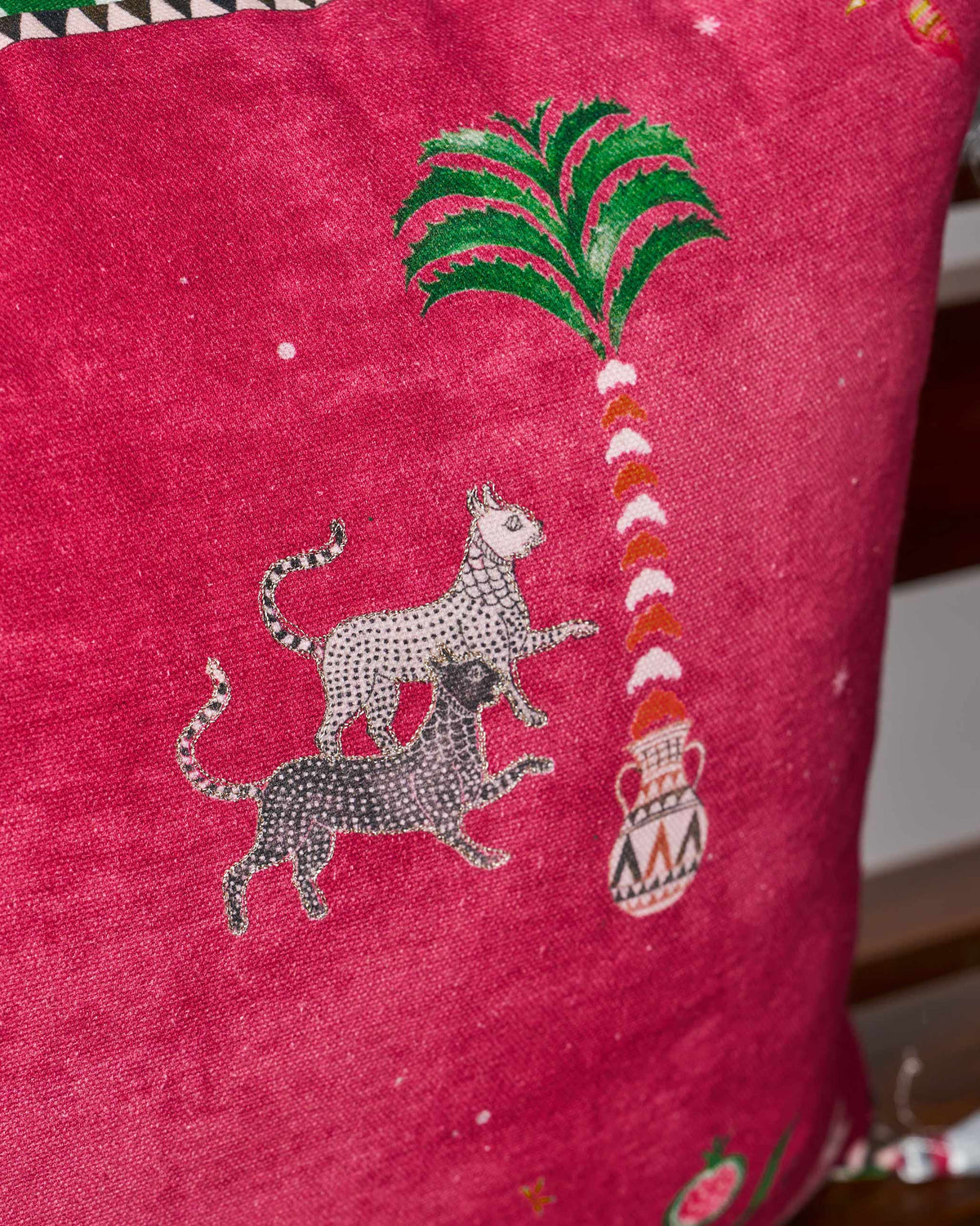 Detail of Harappa cushion leopards and a palm rising from a patterned vase.