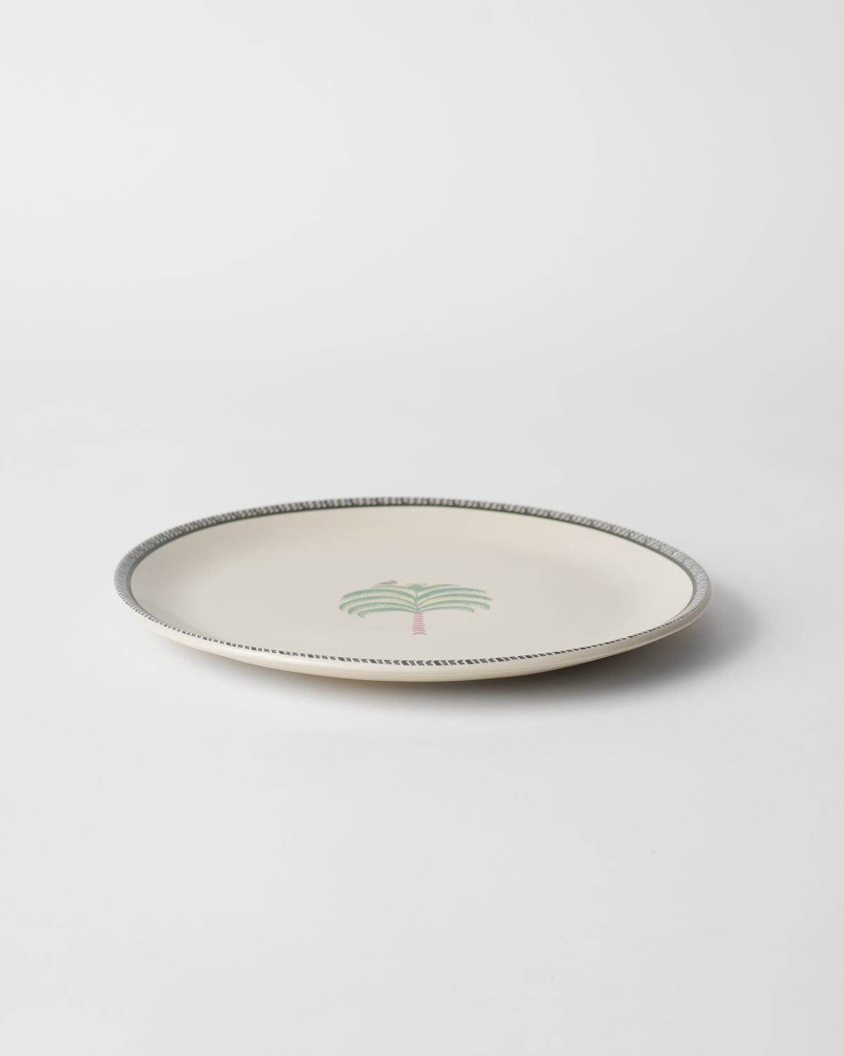 Indus Dinner Plate seen at an angle, with a small palm at the centre.