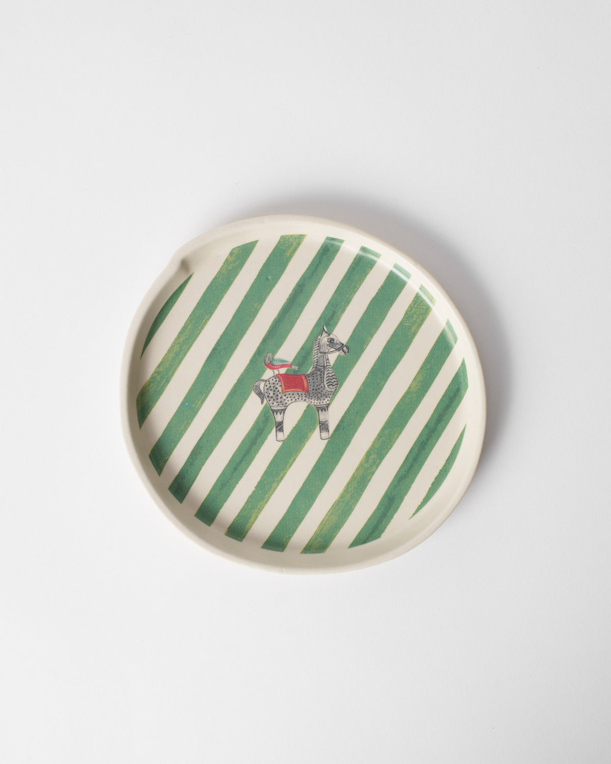 Overhead view of the Indus Dessert Plate with green stripes and a small animal.