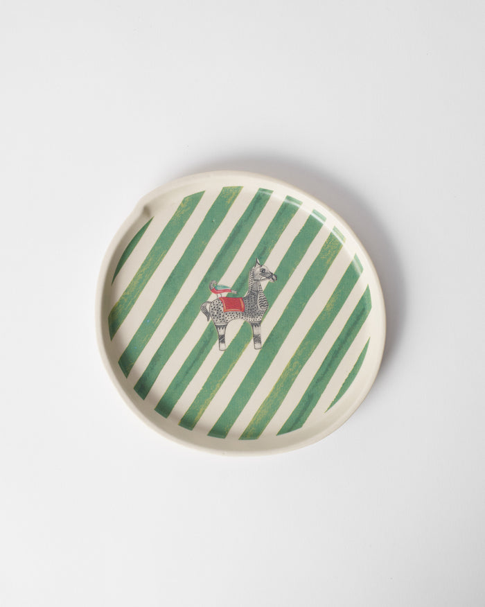 Overhead view of the Indus Dessert Plate with green stripes and a small animal.