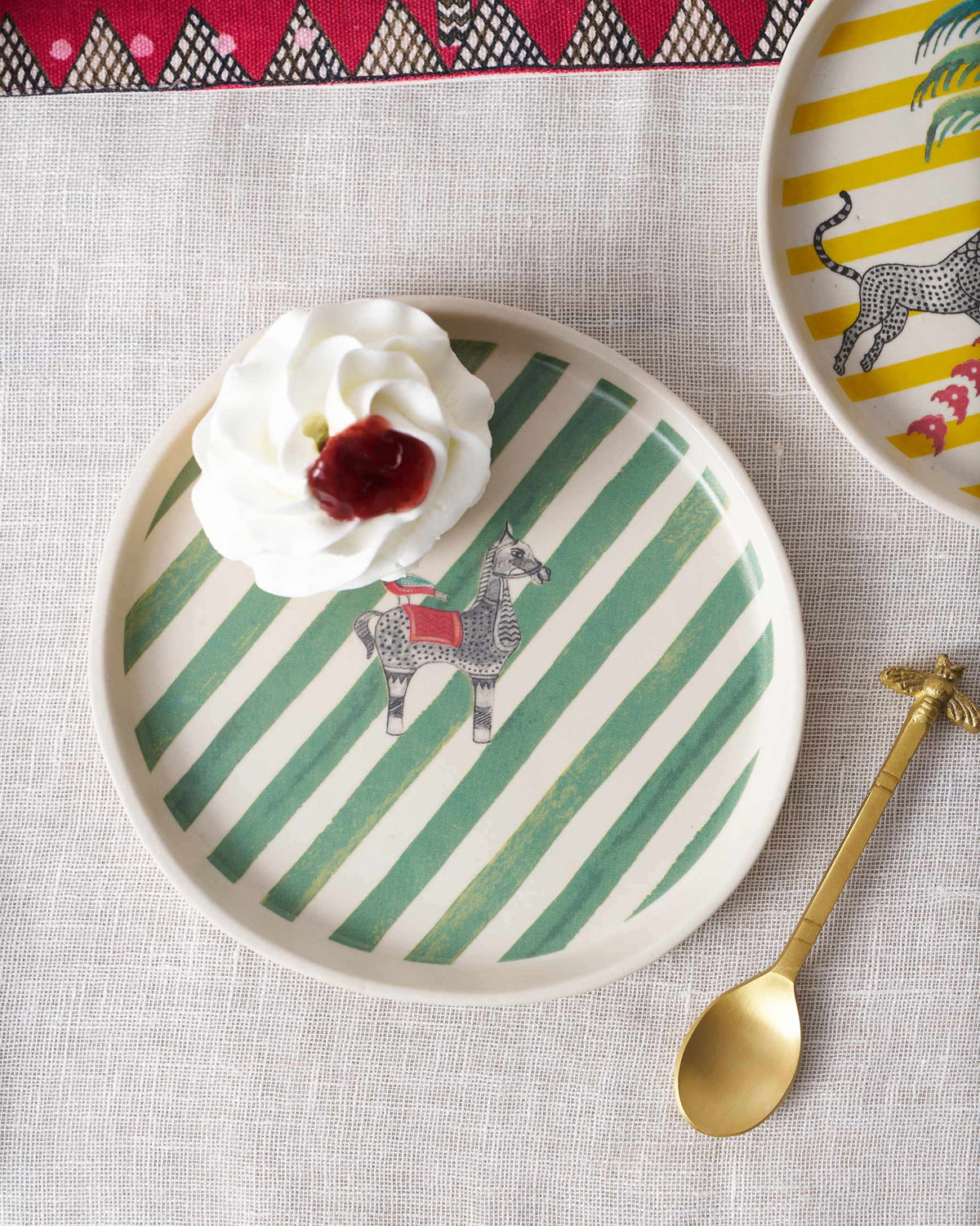 Indus Dessert Plate holding a dollop of cream beside a gold spoon.