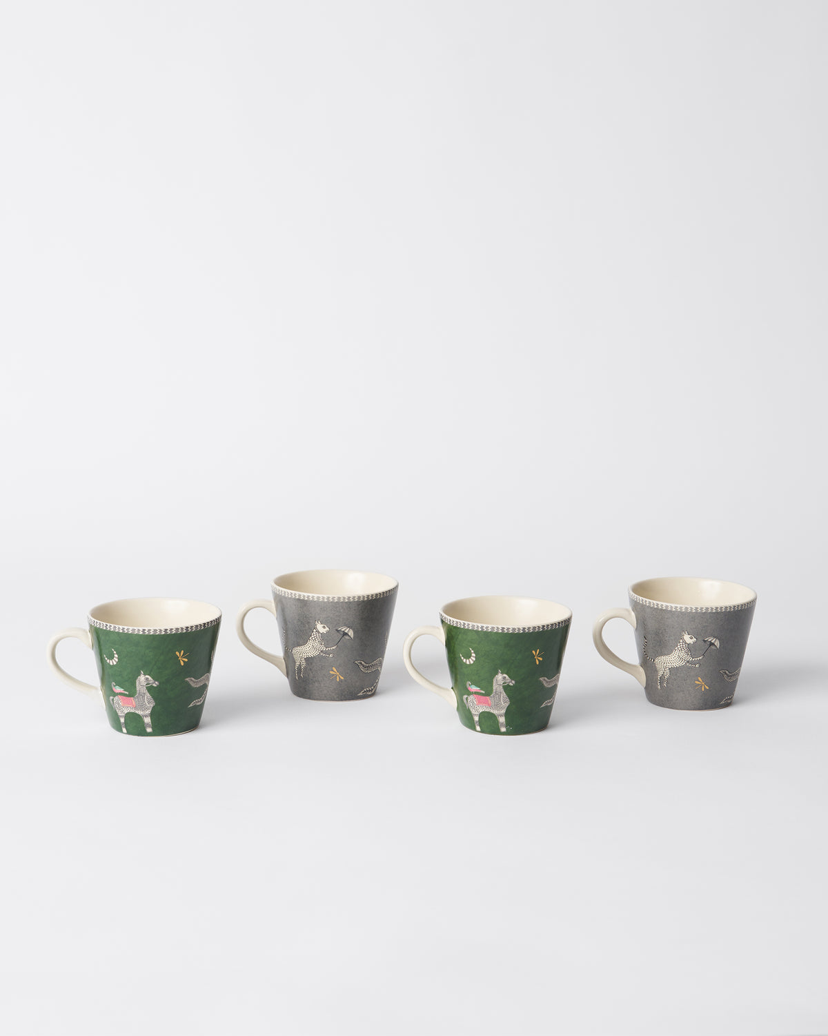 Row of Indus espresso mugs with animal prints and cream handles.