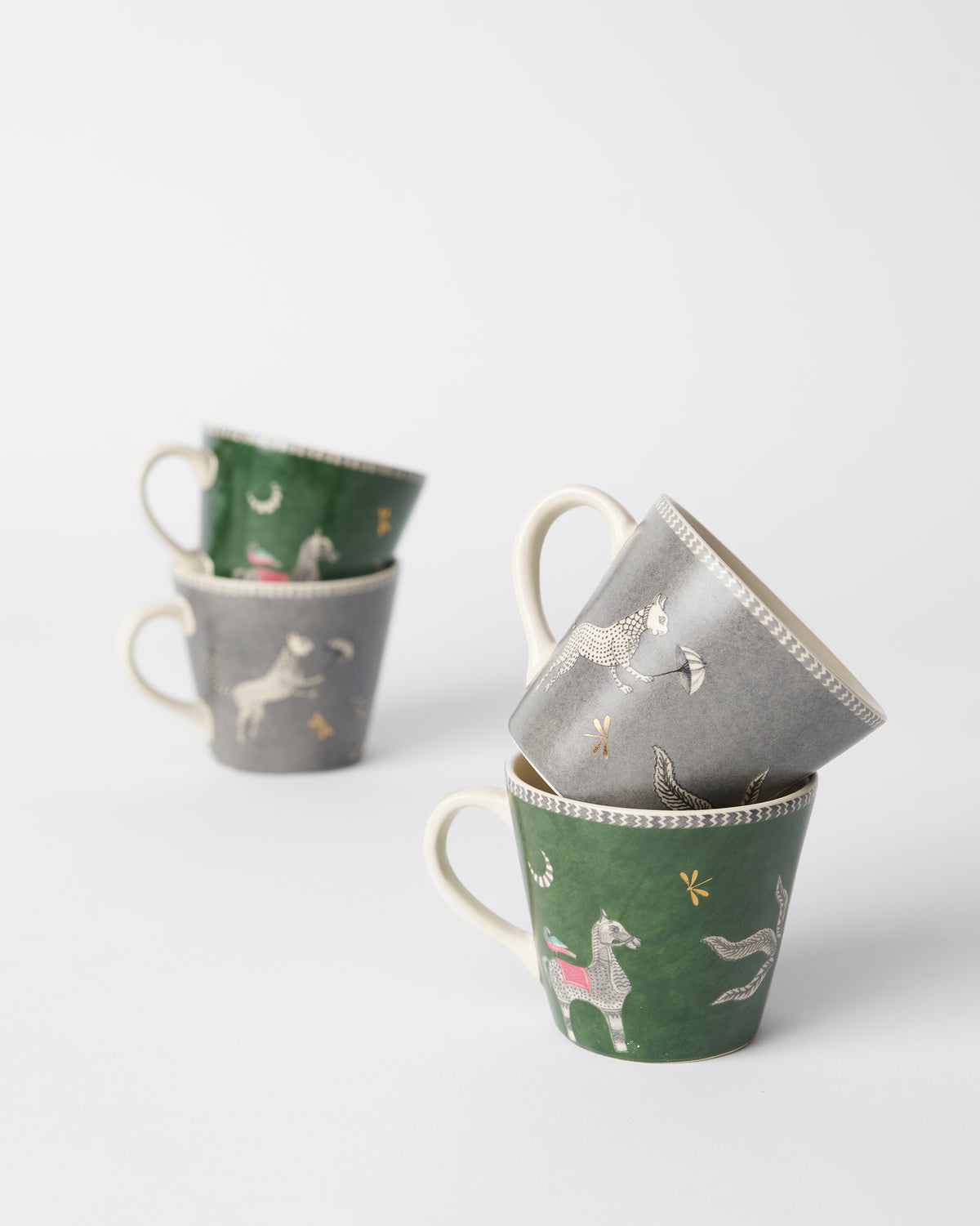 Stacked Indus espresso mugs showing horse and leopard illustrations.