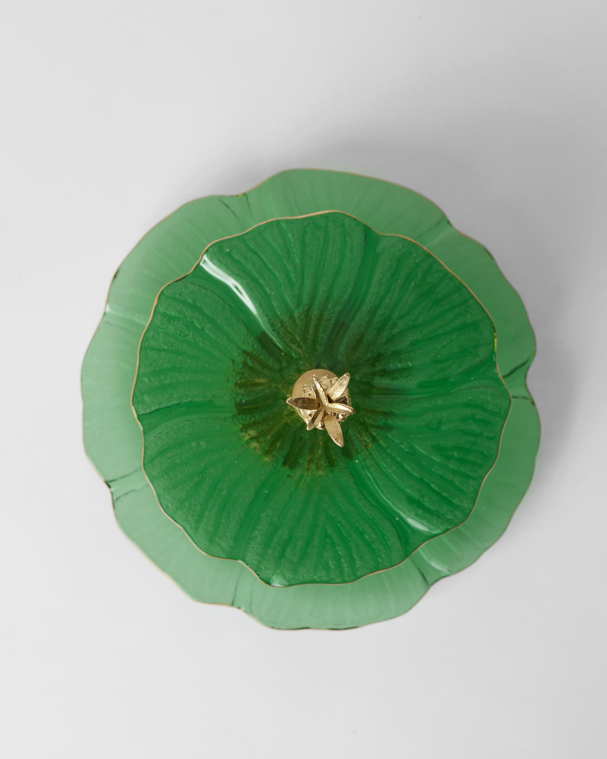Close-up of a Phool Cake Stand tier from above, with a gold centre and ridged glass.
