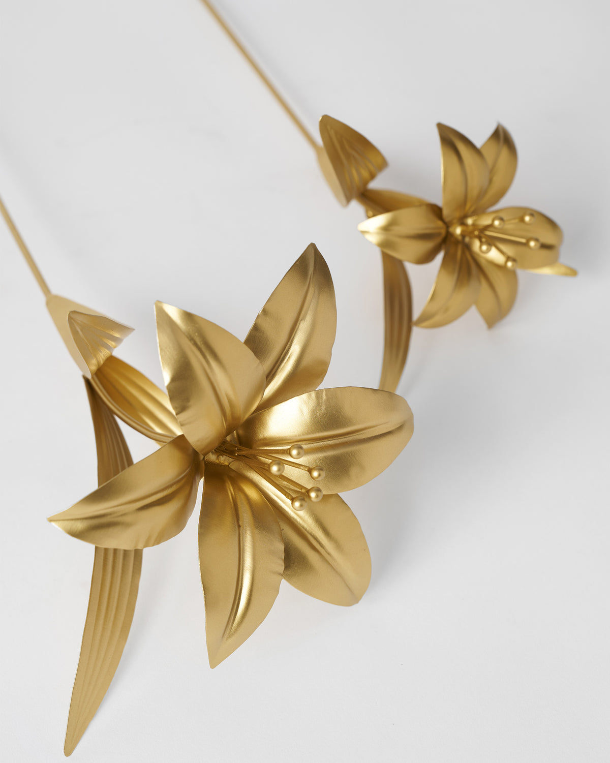 Close-up of gold Lily Accent Pieces with ribbed leaves.