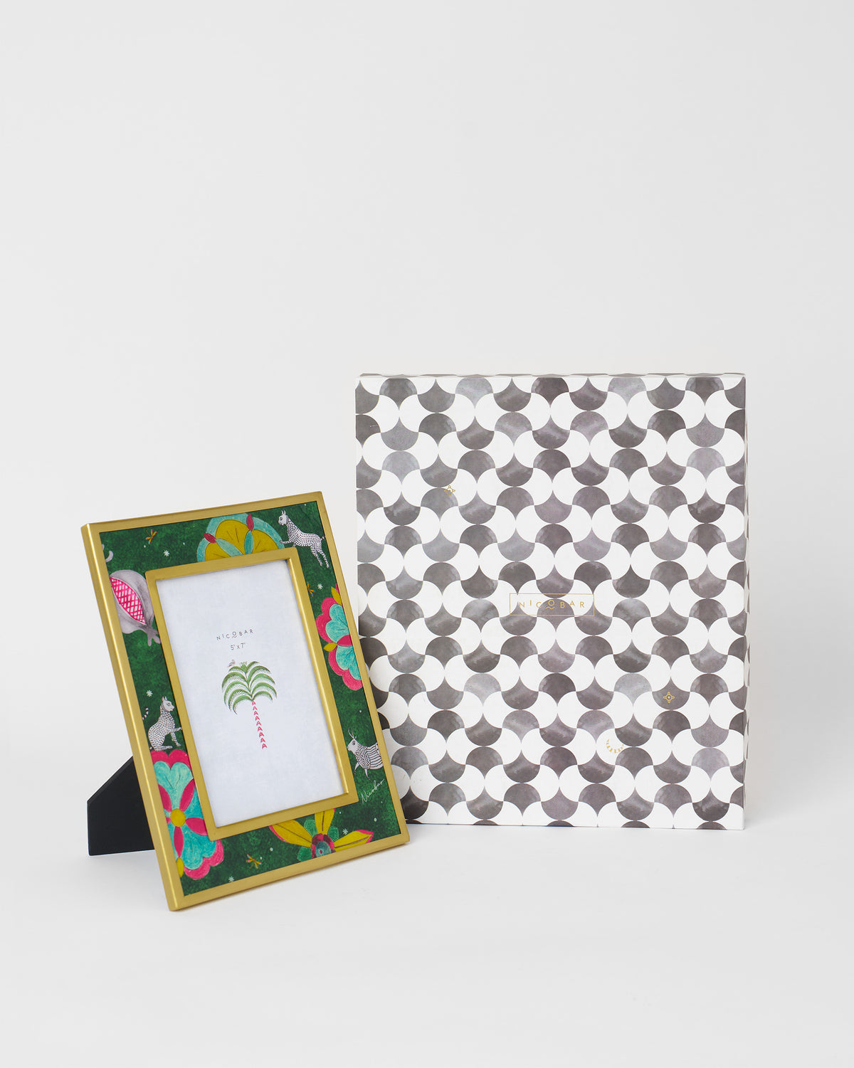 Gold Anara photo frame with a green illustrated border beside its gift box.
