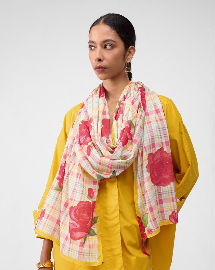 Person wearing a Ruhm scarf with large red roses on a pink and yellow check.