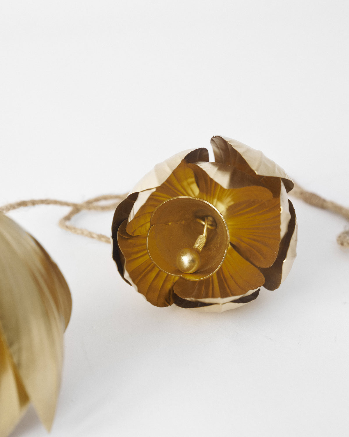 Close-up of a gold lotus bell showing layered petals and a spherical clapper.