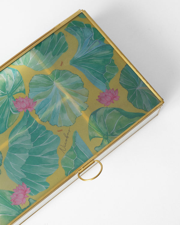 Close view of the lid, green lily pads and pink lotuses on gold
