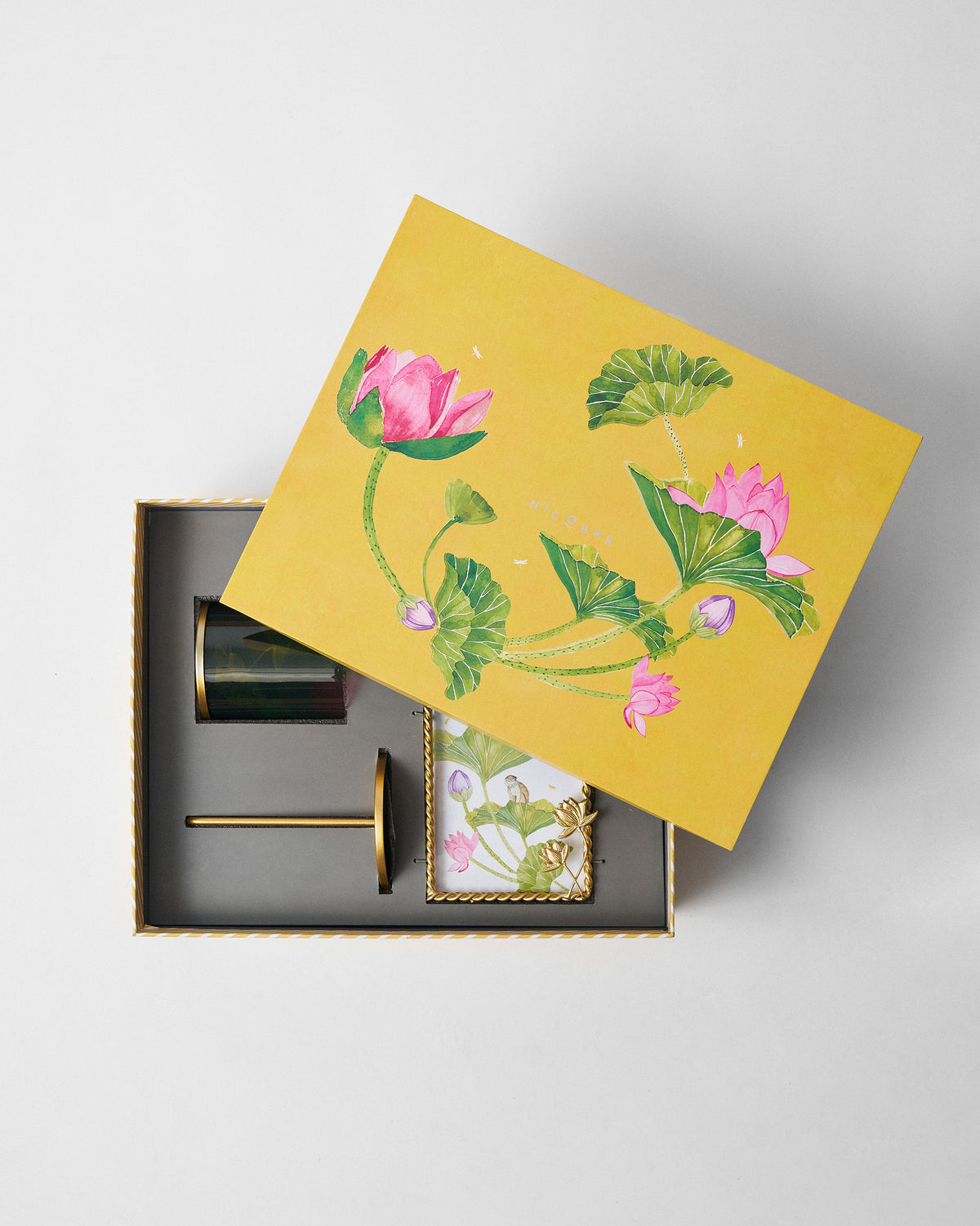 Lotus Grove gift box open to show green glass, brass tool and frame.