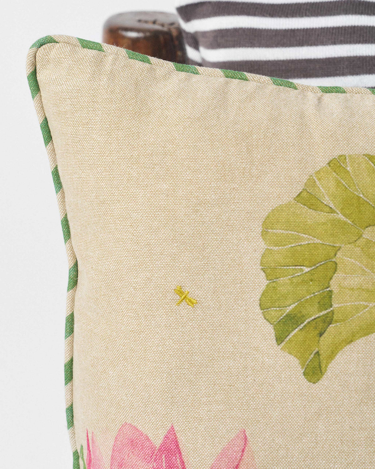 Close-up of Lotus cushion cover with green leaf and yellow dragonfly embroidery.