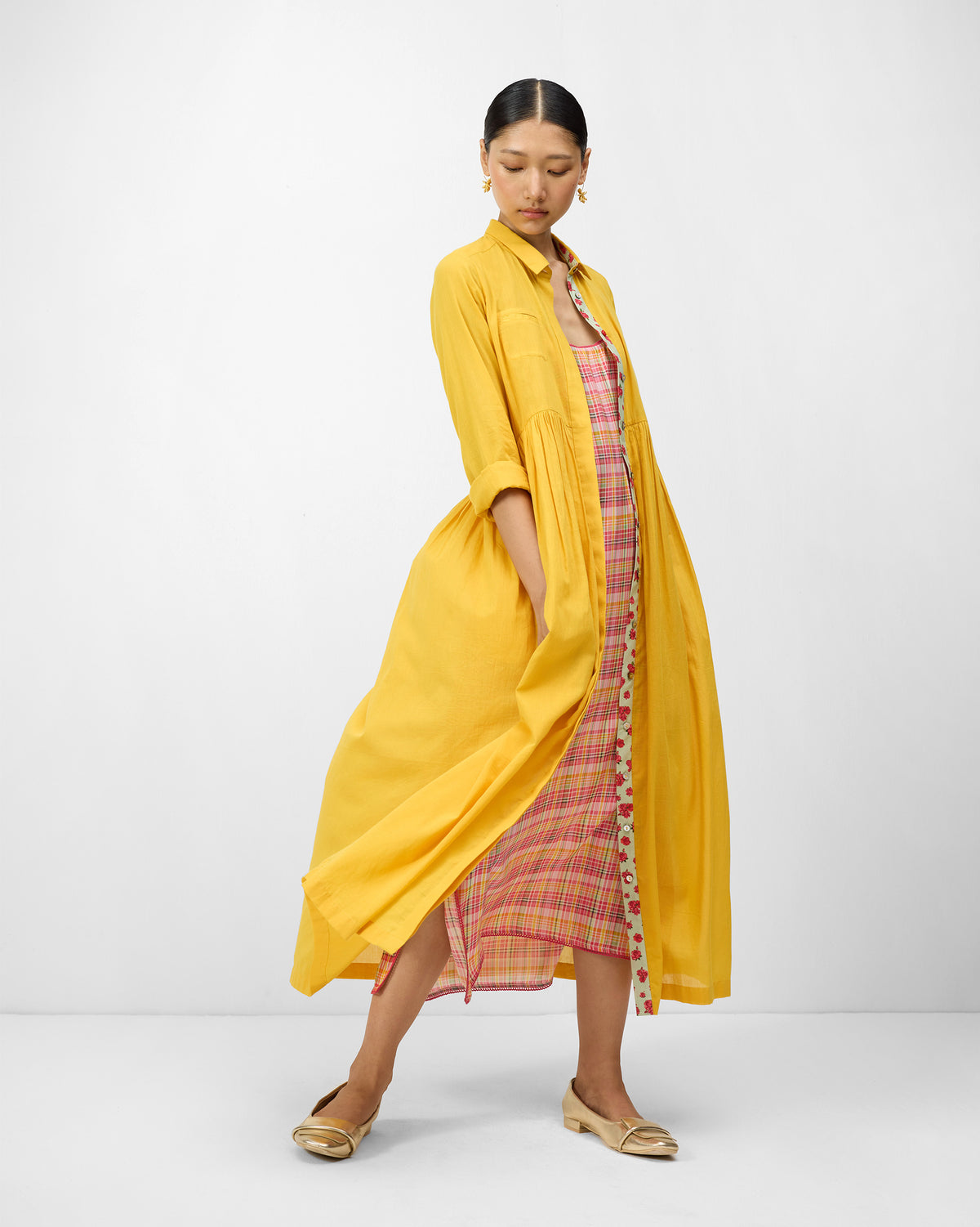 Aurora Dress worn open in turmeric yellow over a pink check slip.