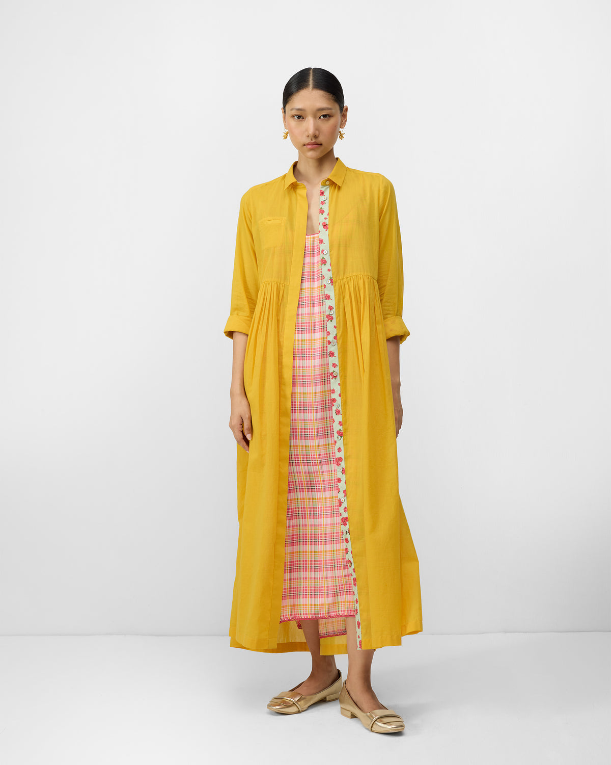 Aurora Dress open in turmeric yellow over a pink check slip.