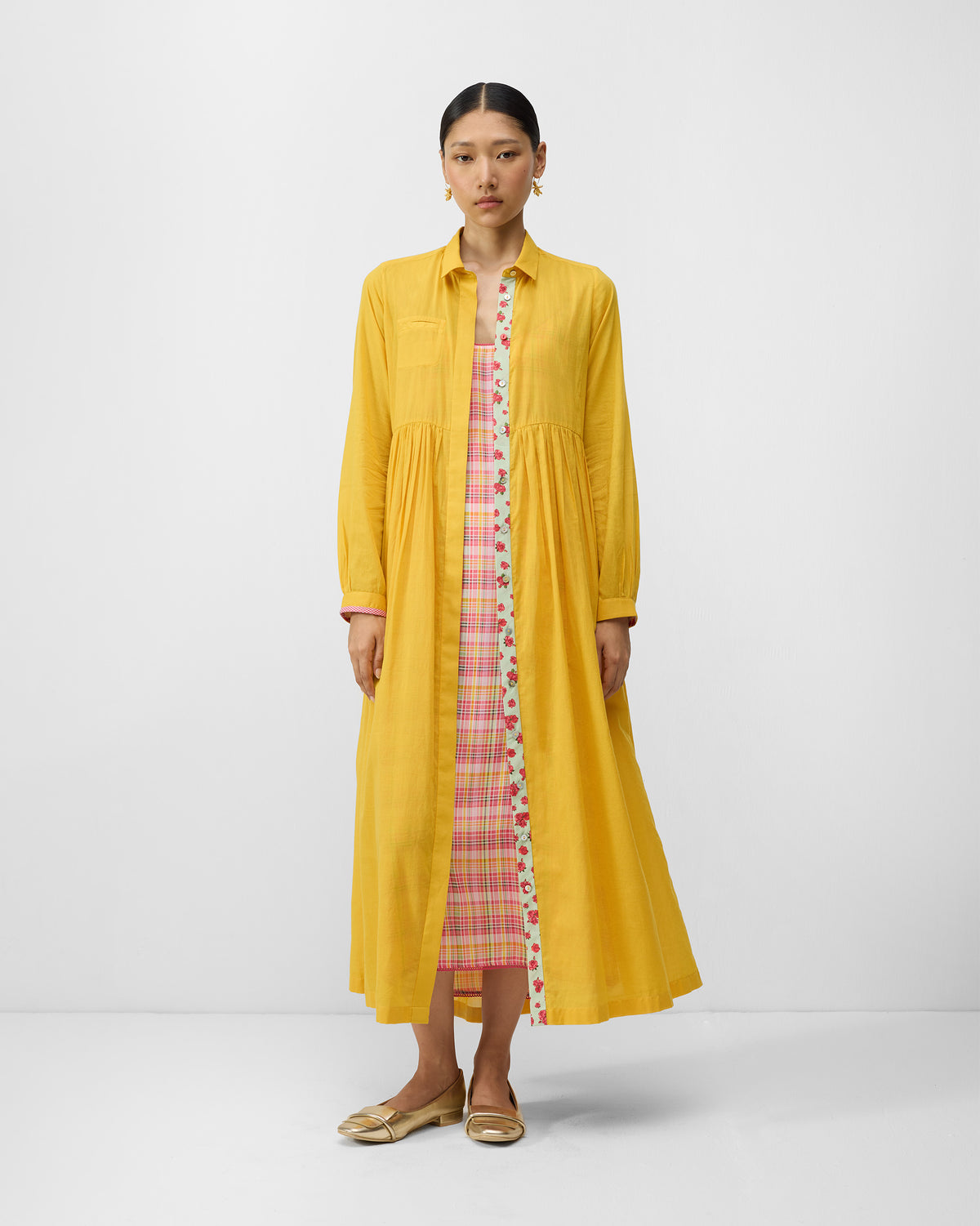 Aurora Dress layered open over a pink check slip in turmeric yellow.