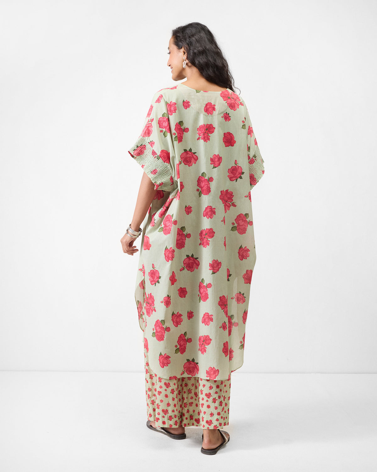 Back of a mint Calicut kurta with pink rose print worn by a person.