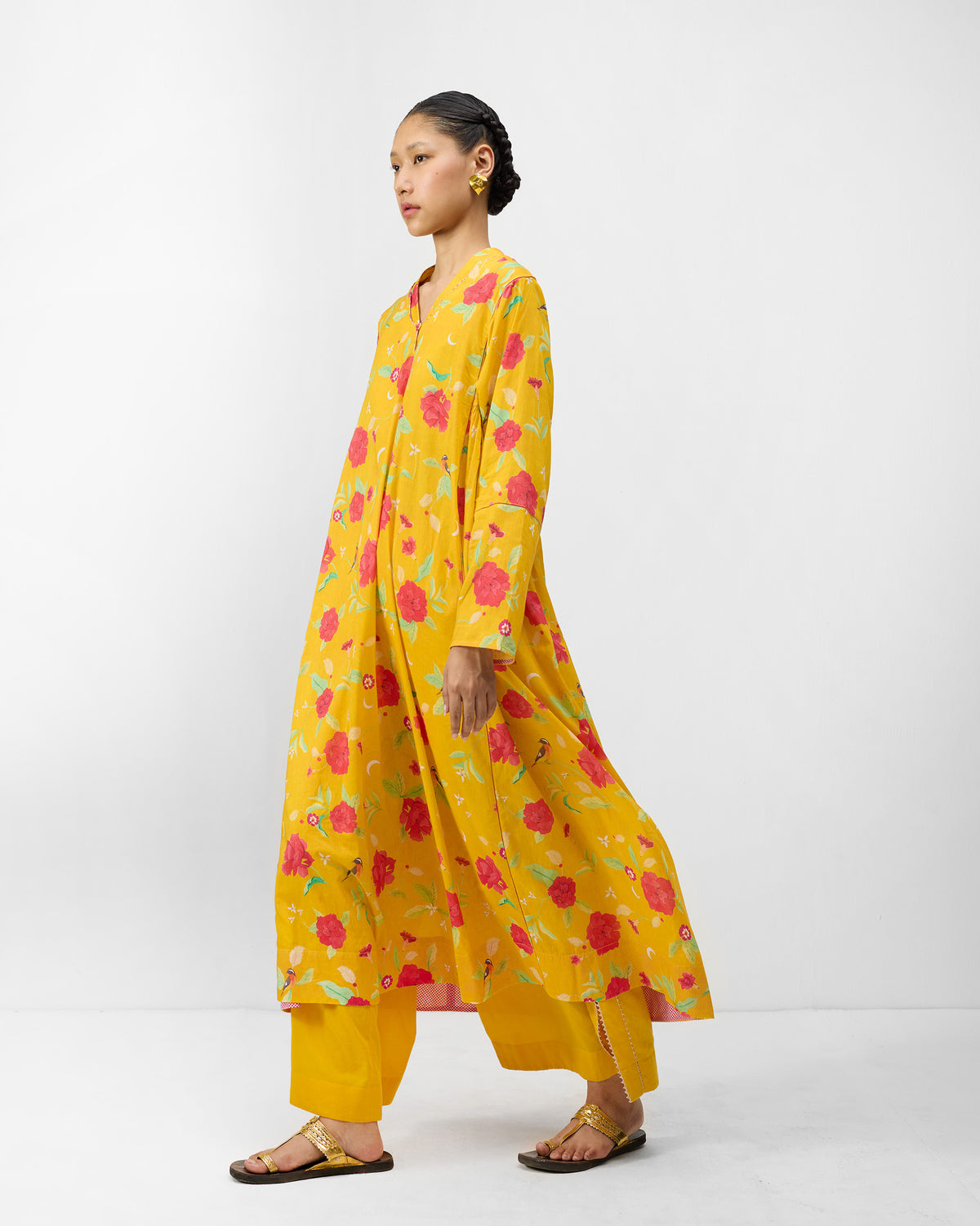 Three-quarter view of a turmeric yellow Amreli kurta with peony print.