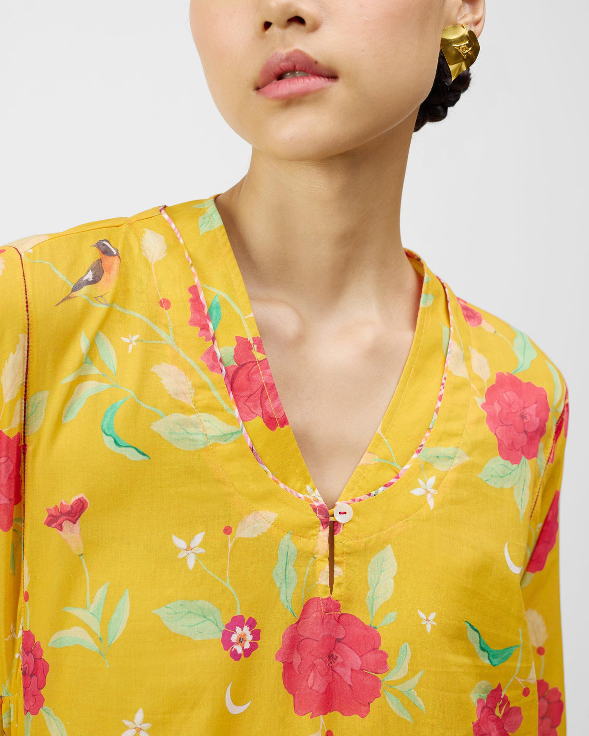 Close-up of the V-neck on a turmeric yellow Amreli kurta with peony print.