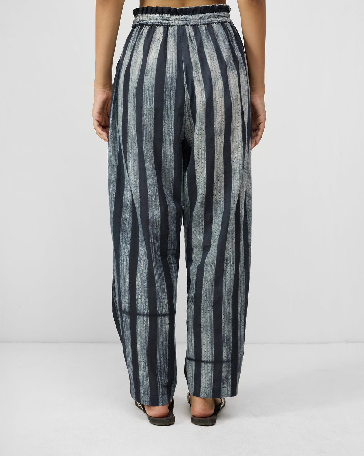 Back of charcoal and ivory striped Areca Pants with a paperbag waist.