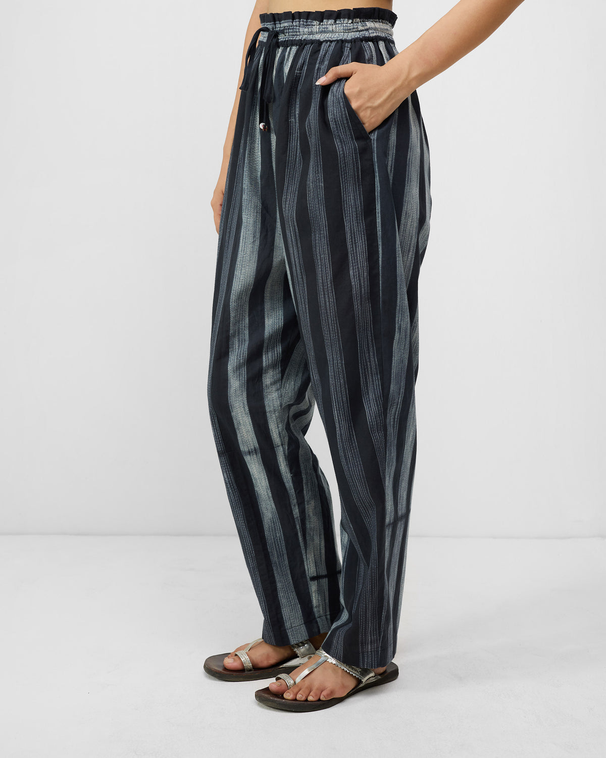 Side view of charcoal and ivory striped Areca Pants with a side pocket.