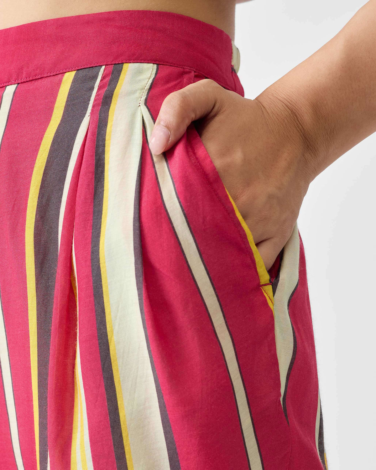 Close-up of pink striped Narrow pants showing a side pocket.