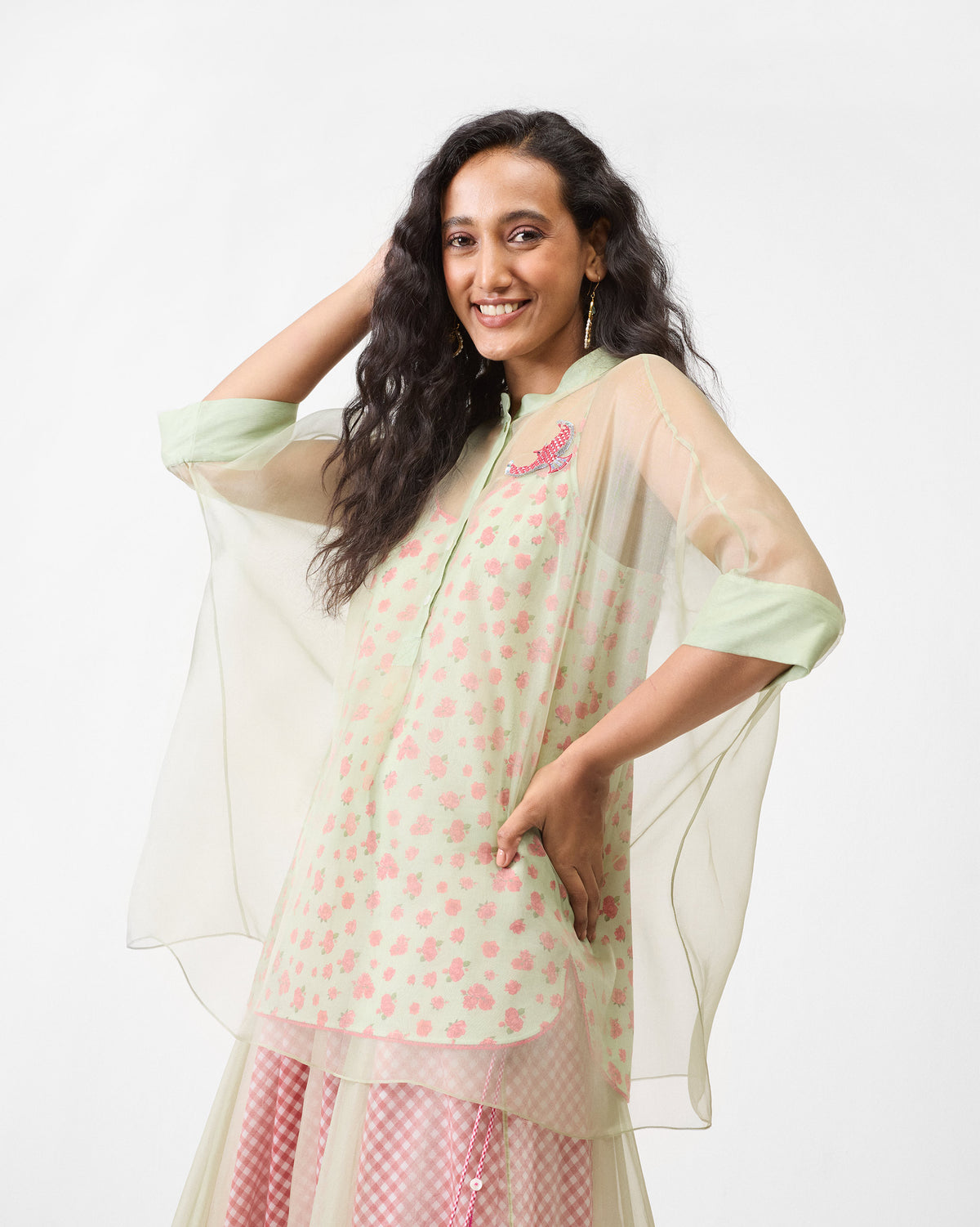 Person wearing a mint Jaisalmer shirt over a floral slip with a bird embroidery.