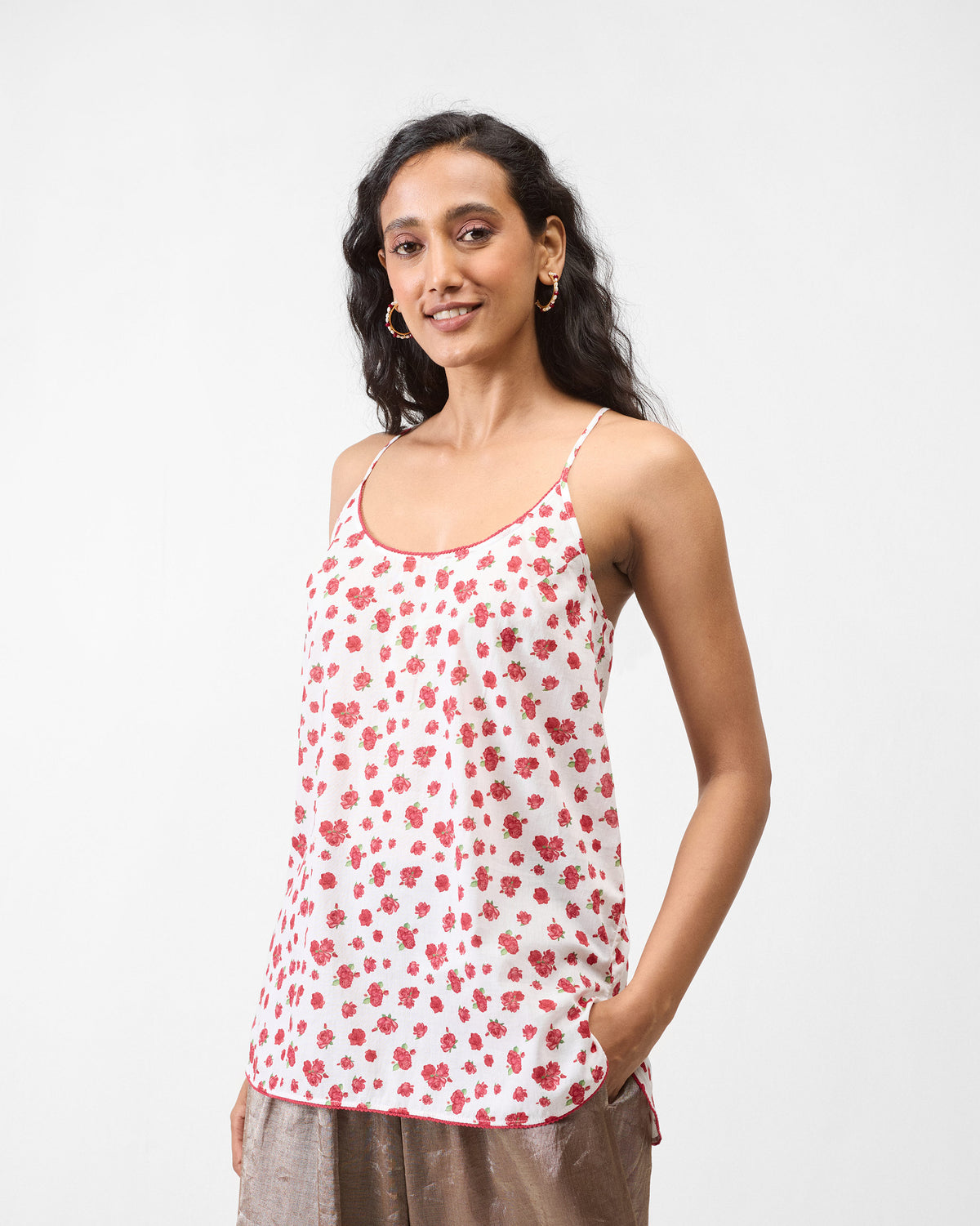Person wearing a white floral slip with spaghetti straps.