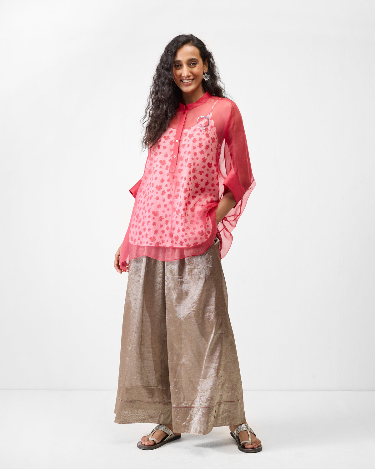Person wearing a sheer watermelon shirt over a floral slip.