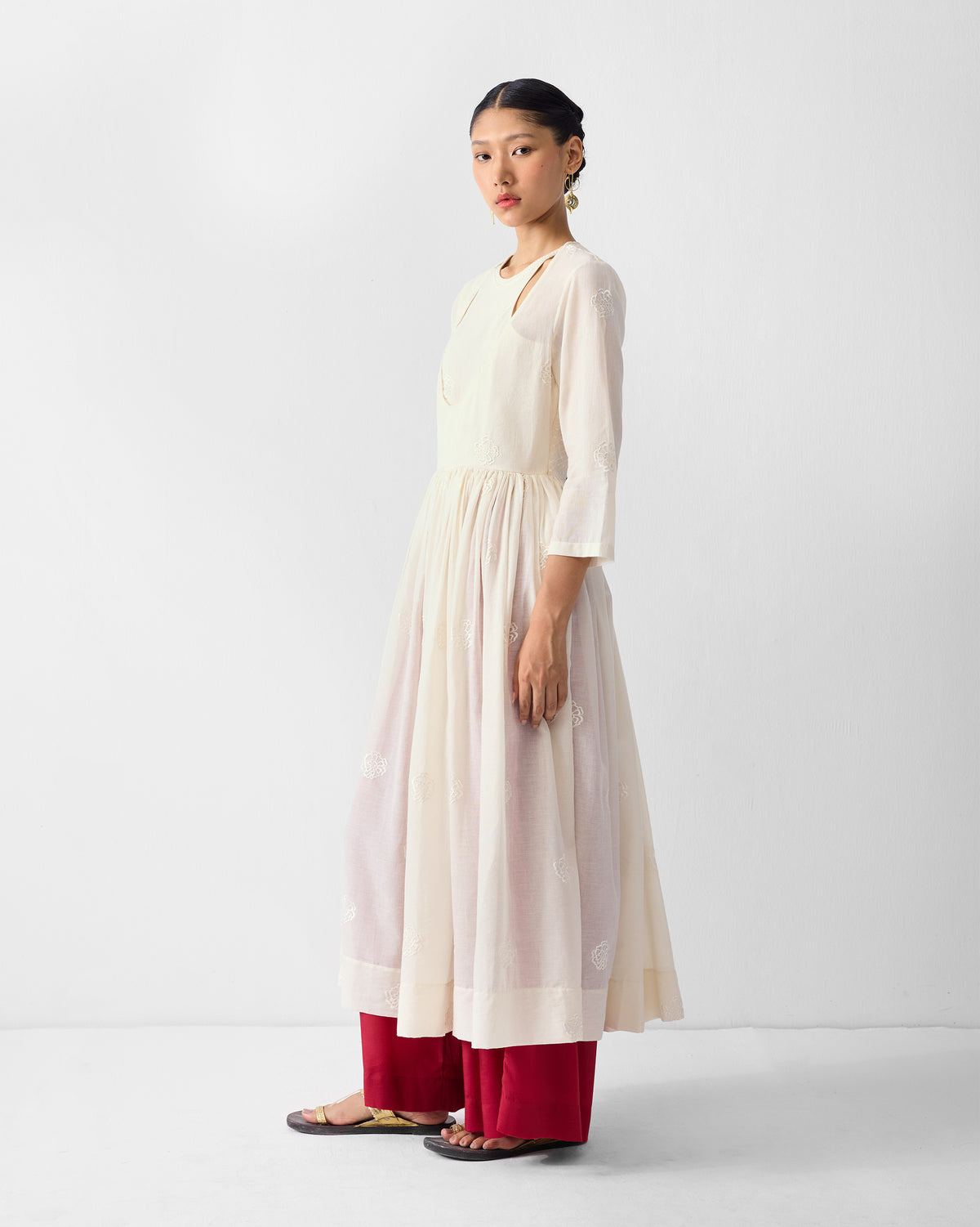 Side view of an ivory embroidered Fit & Flare Angrakha with a gathered skirt.
