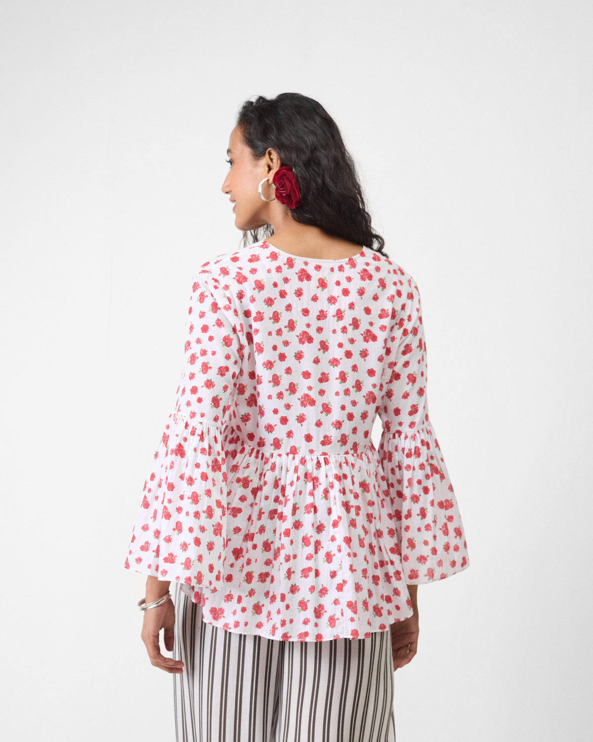Back of a white watermelon print ruffle top with flared sleeves.