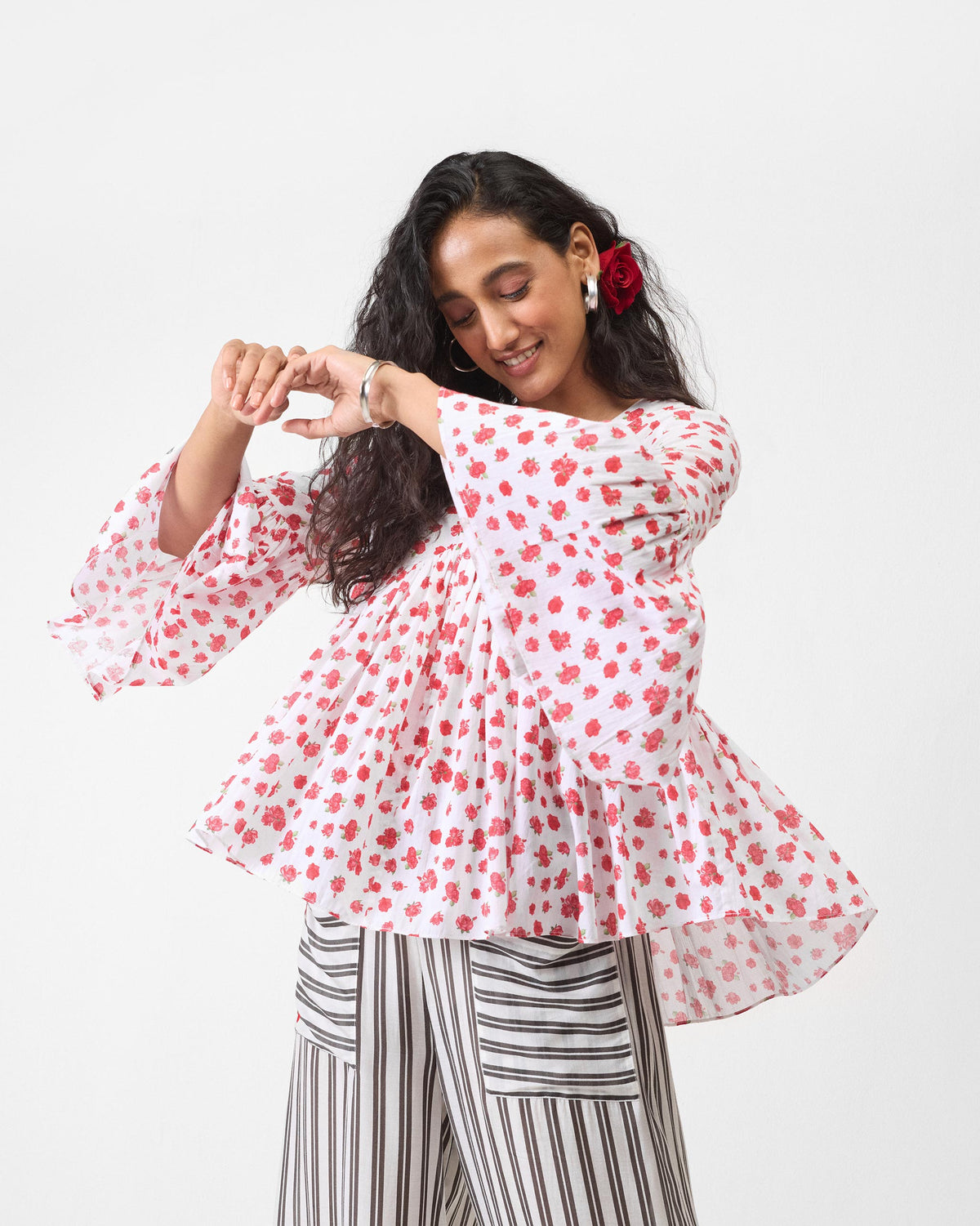 Person wearing a white watermelon print top with bell sleeves.