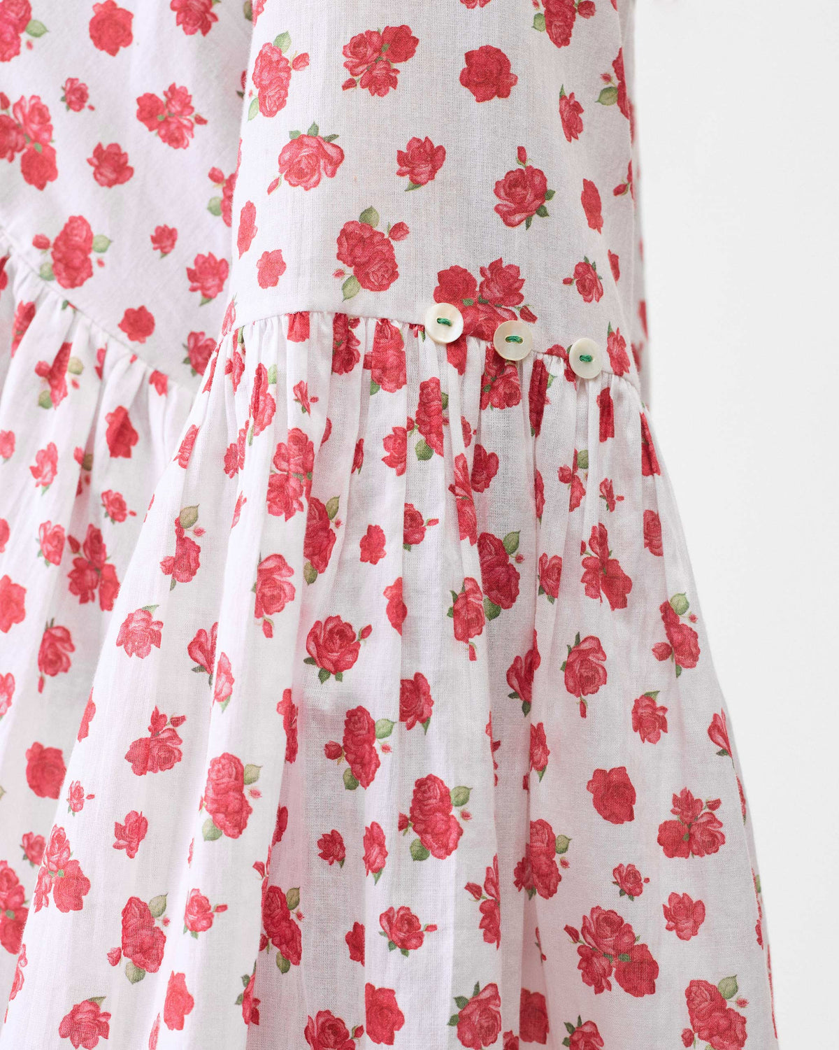 Close-up of the gathered tier on a white watermelon print ruffle top.