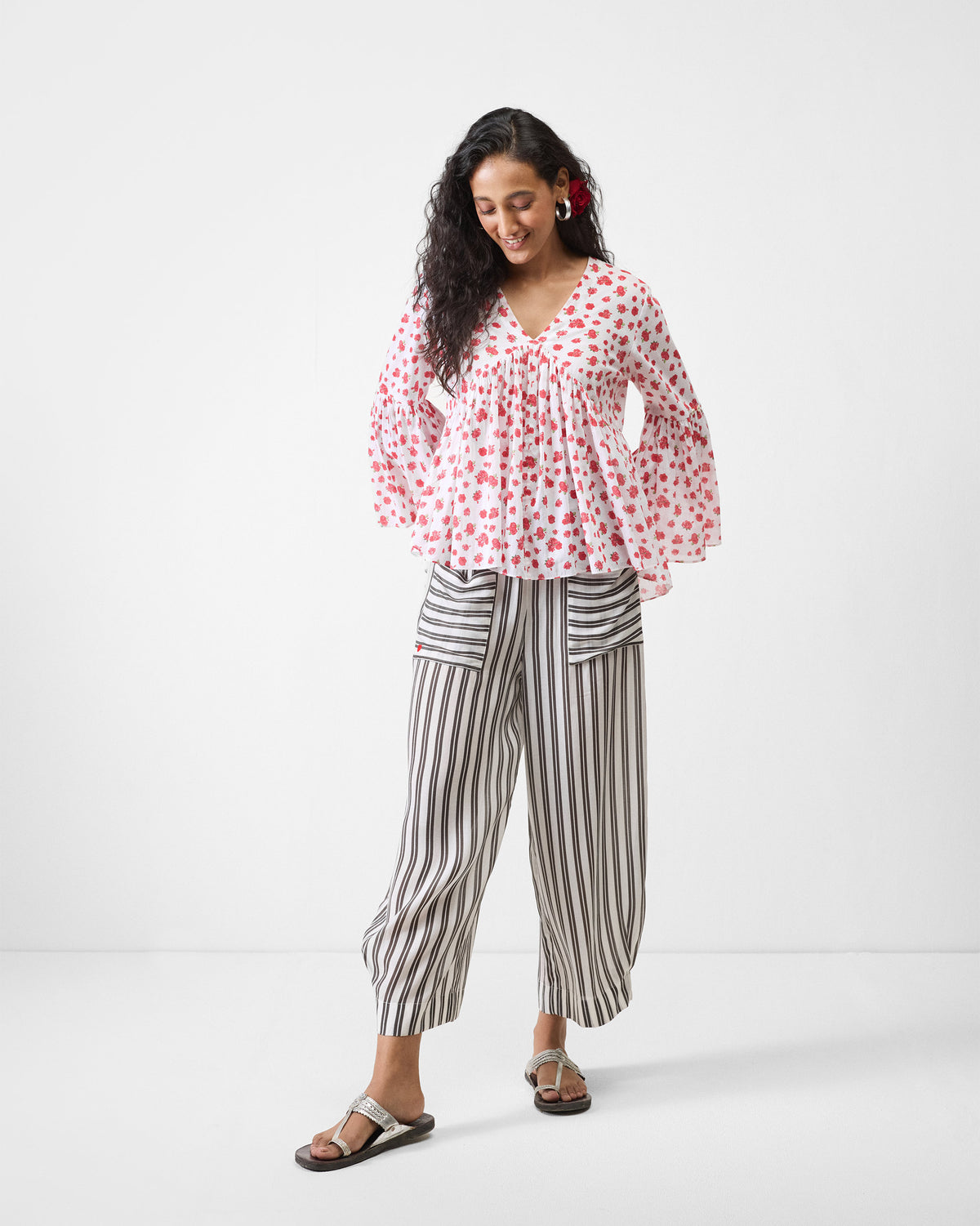 Person wearing a long-sleeve white watermelon print ruffle top.