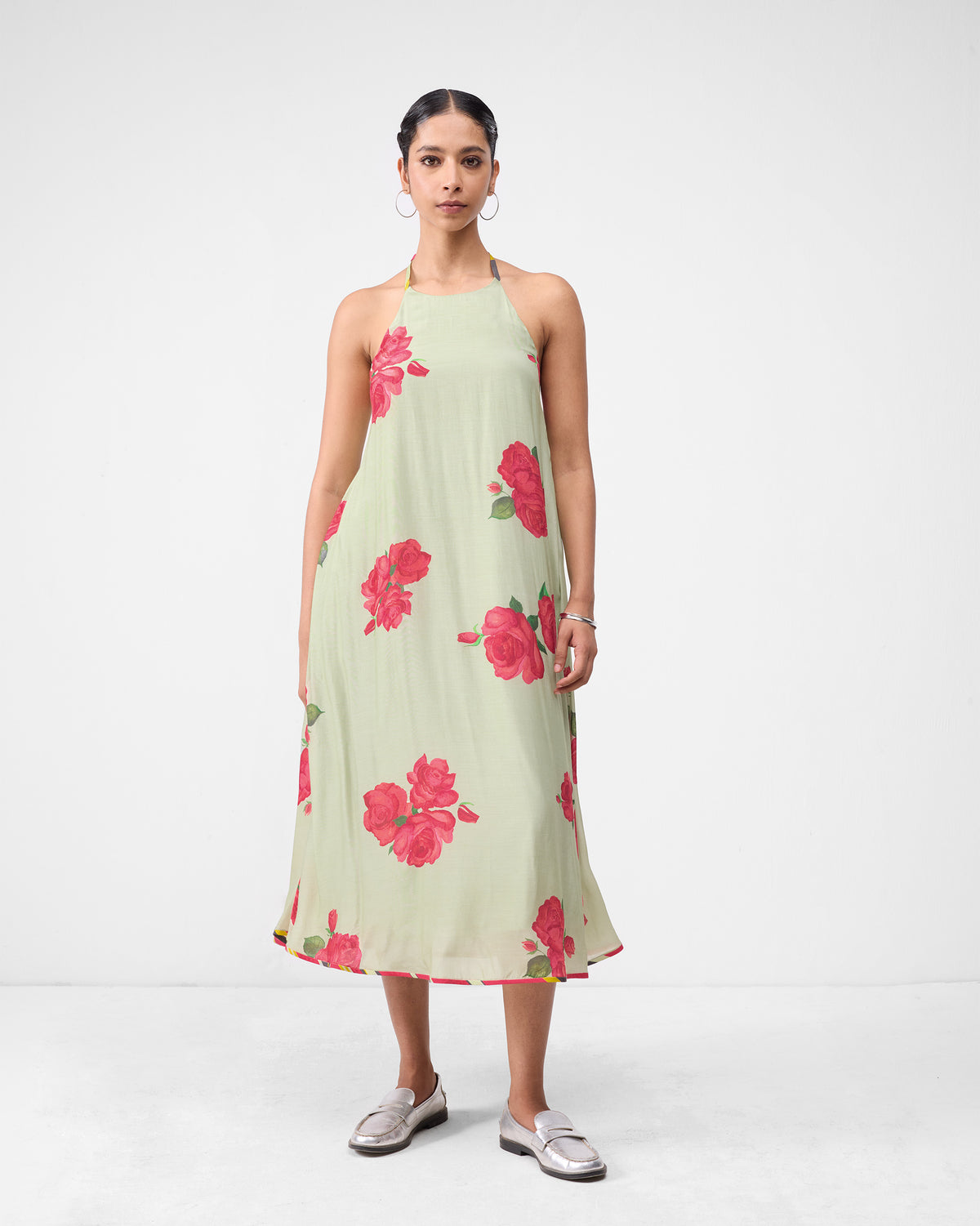 Person wearing a mint watermelon print scoop back dress with a halter neck.