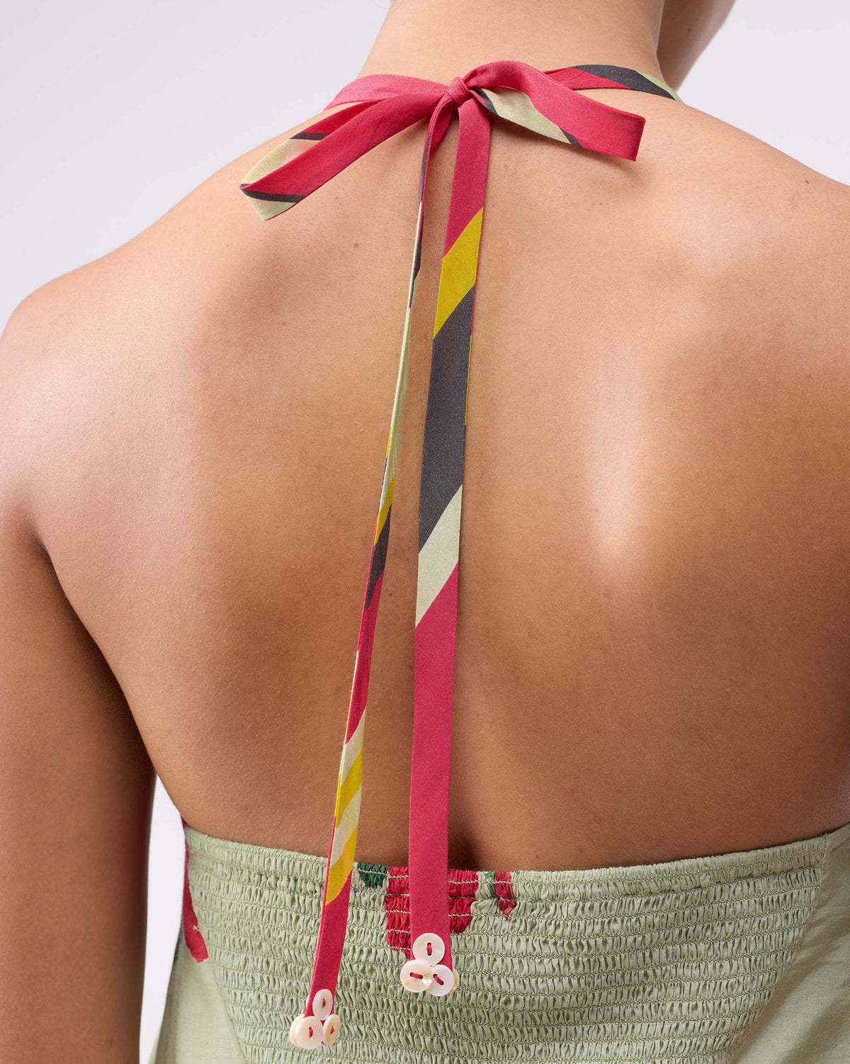 Close-up of the scoop back dress striped neck ties over a smocked back panel.