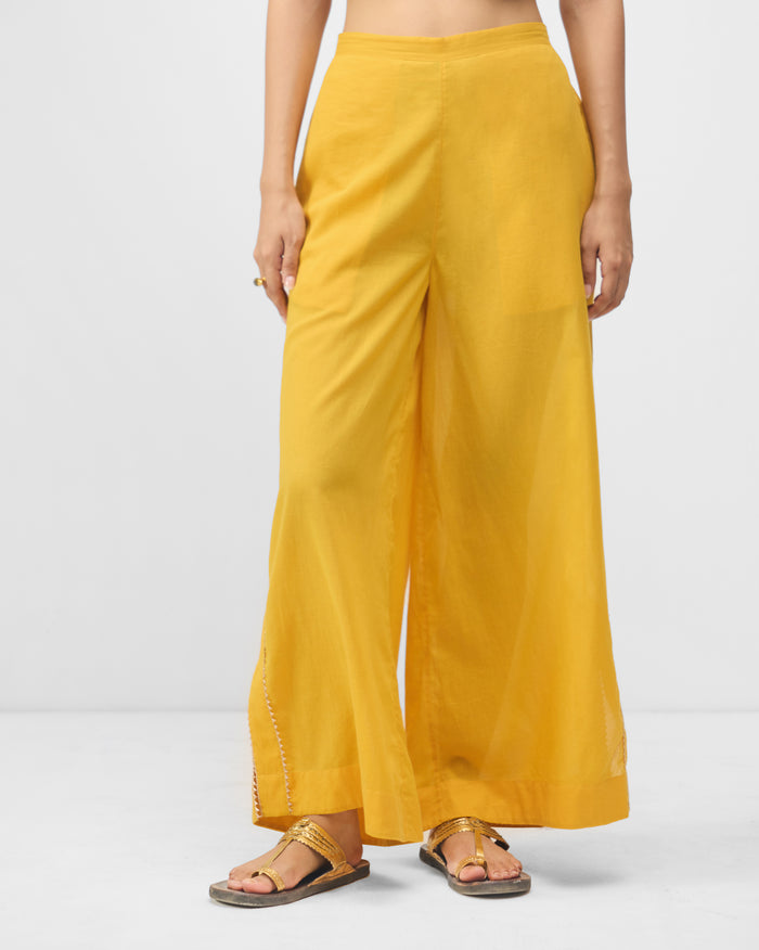 Person wearing turmeric yellow Ayat pyjamas with wide legs.