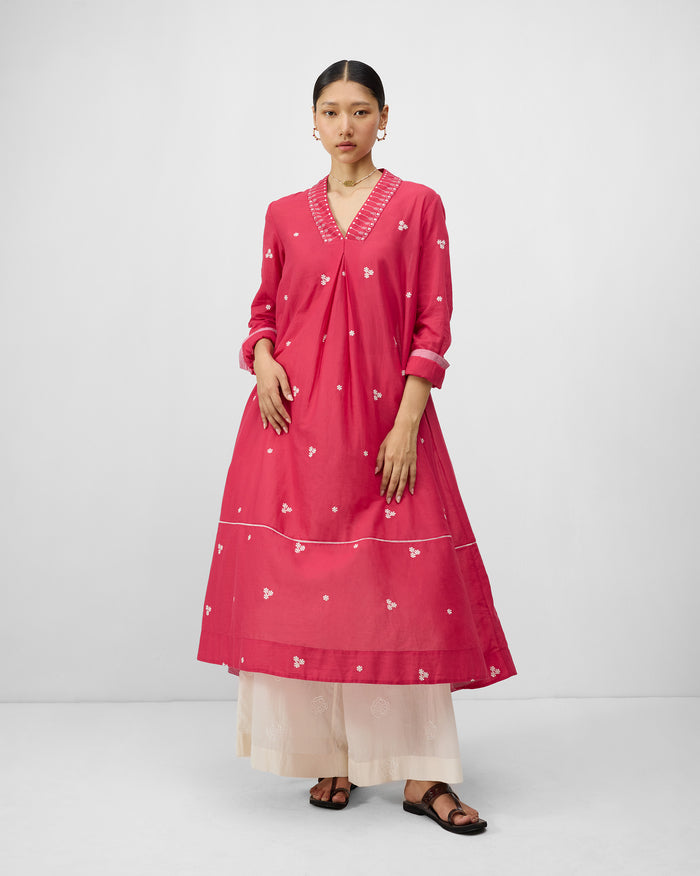 Person wearing a watermelon pink Banko kurta with ivory neckline embroidery.