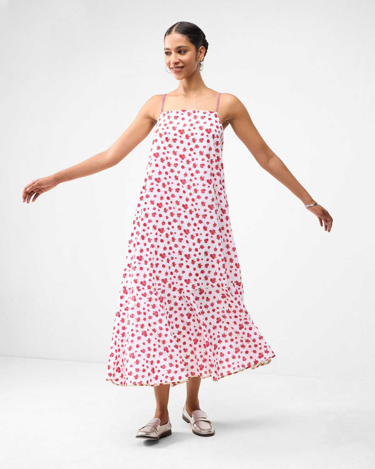 Person wearing a white Kimsuka Dress with a watermelon floral print.