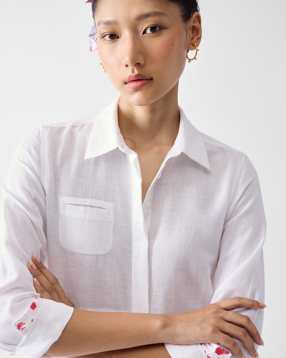 Close-up of a white shirt dress collar with a chest pocket and red cuff lining.
