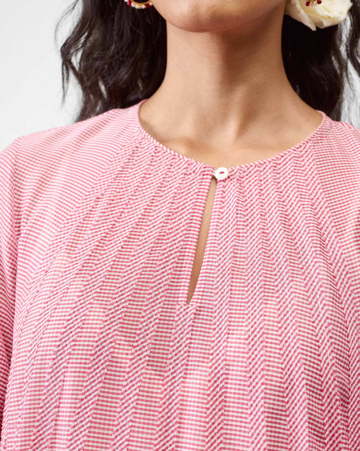 Close-up of the keyhole neckline on a pink and white striped Pattaya kurta.