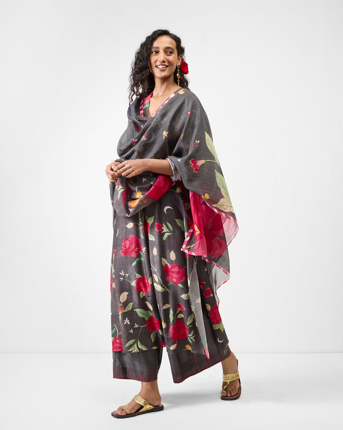 Person wearing a charcoal floral kurta with a matching dupatta.
