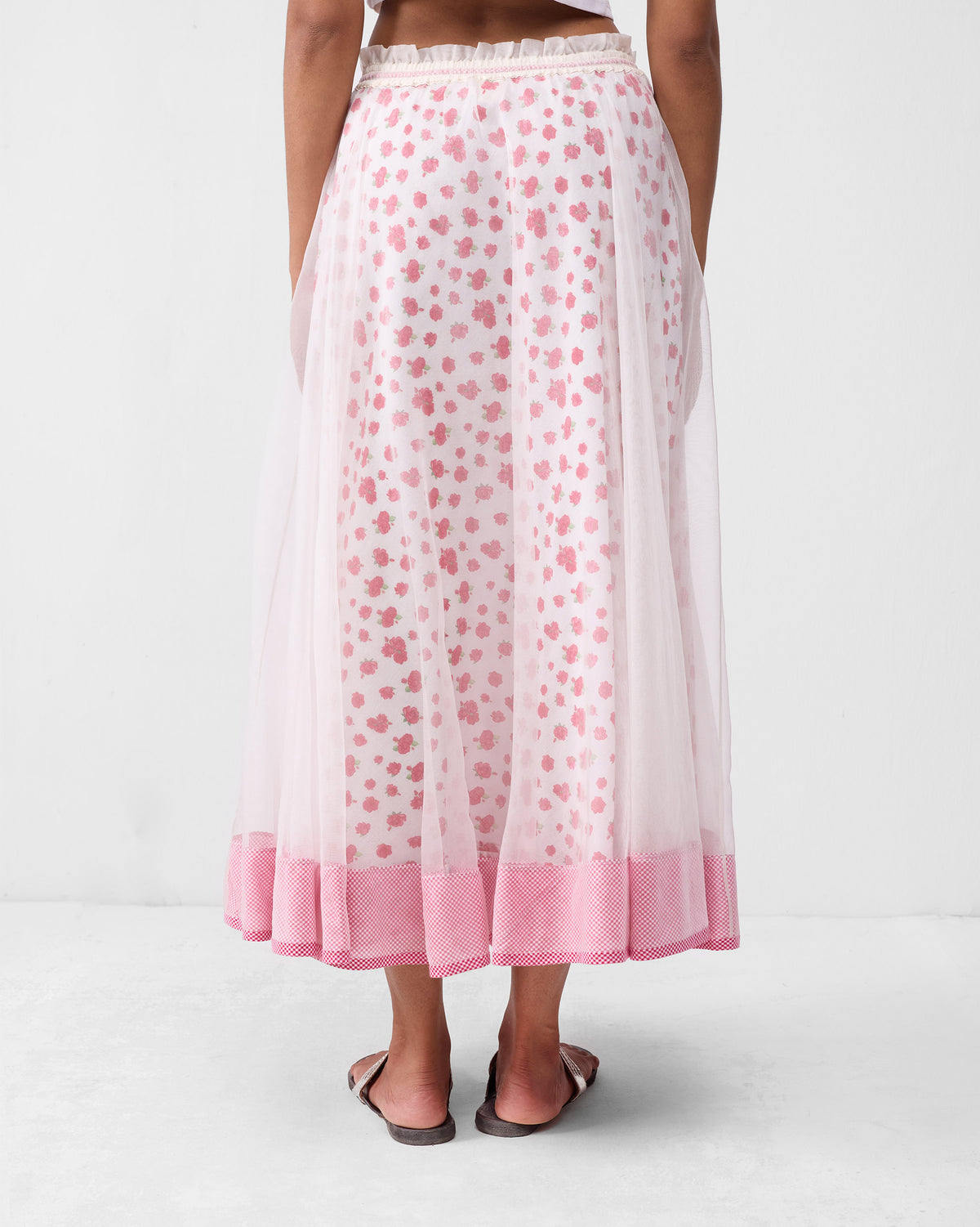 Back of an ivory Pushkar skirt showing a gathered waist and pink hem border.