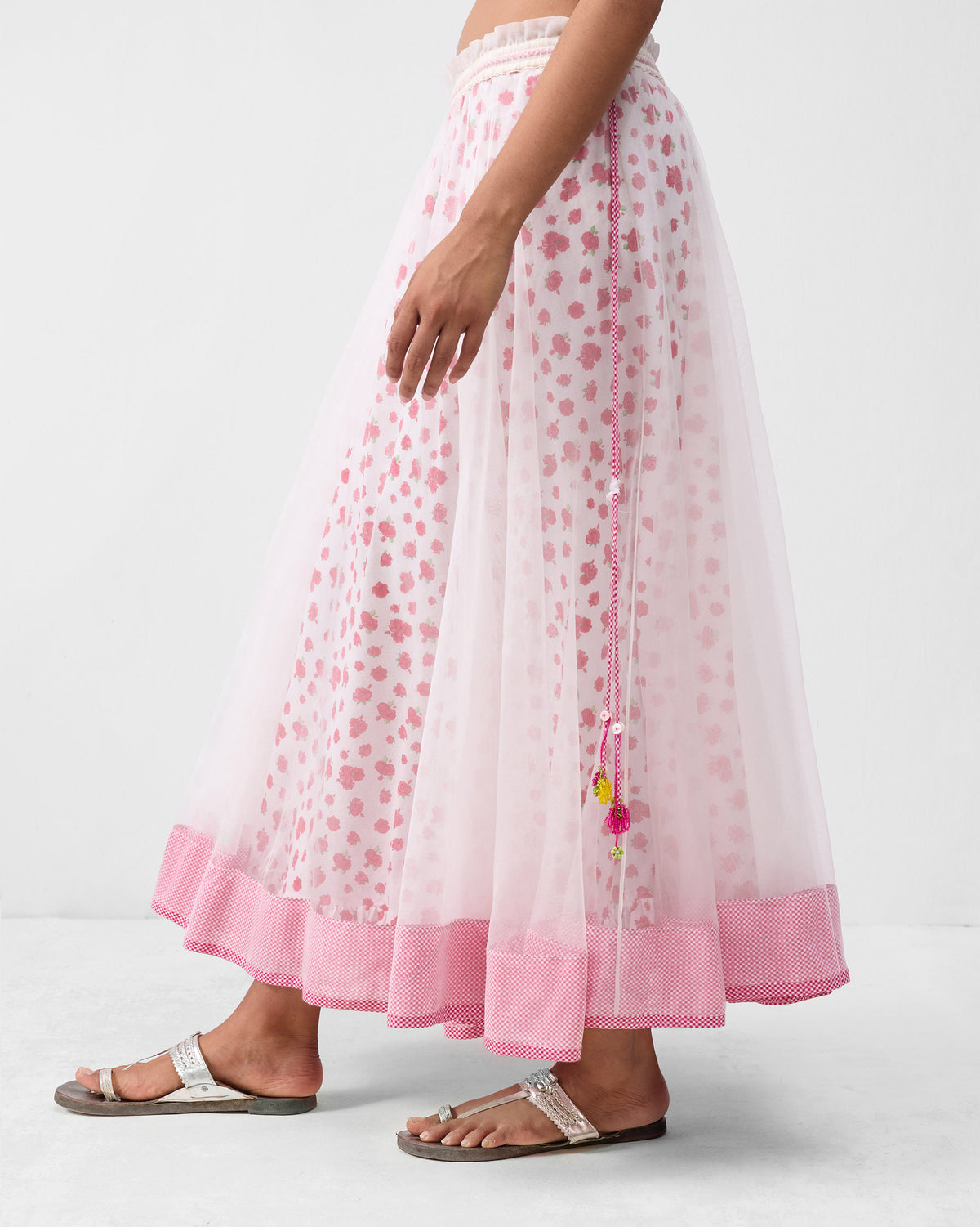 Side view of a Pushkar skirt with a beaded tassel drawstring at the waist.