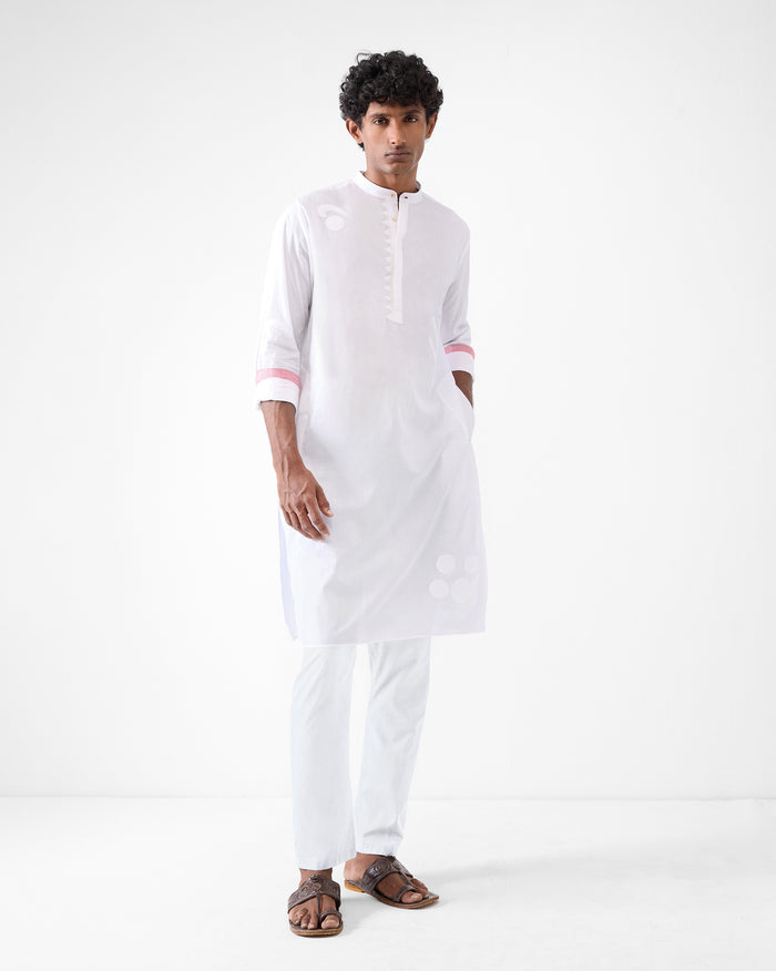 Person wearing a white Neckband Kurta with tonal appliqué and pink cuff accents.