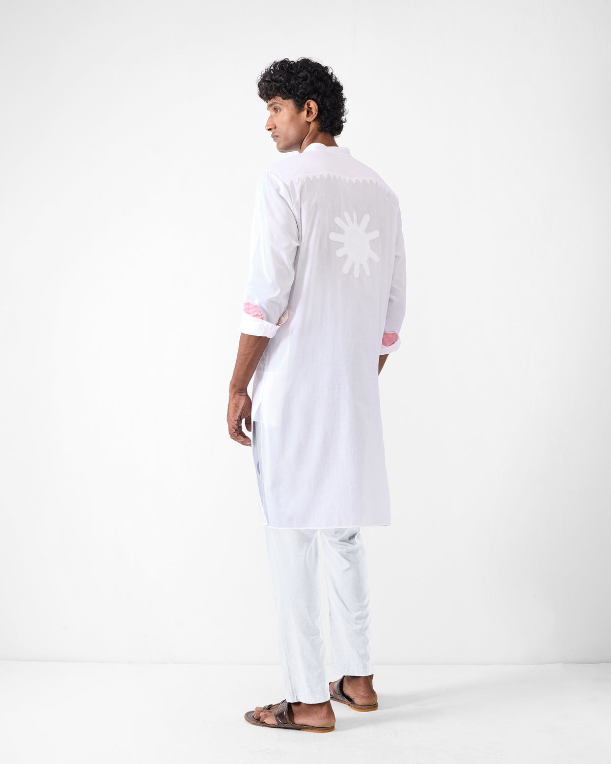 Back of a white Neckband Kurta with a sunburst appliqué and scalloped yoke.