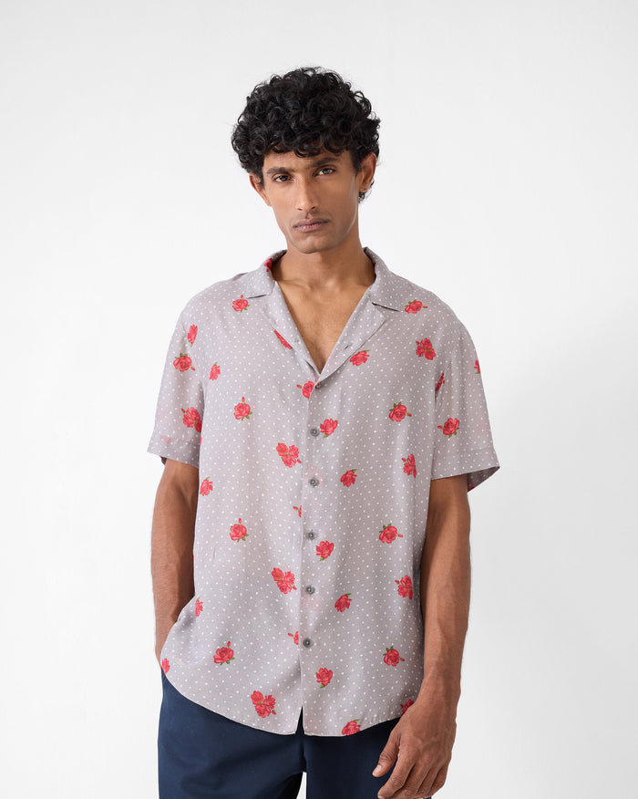 Person wearing a charcoal Mistari Shirt with red rose print and white dots.