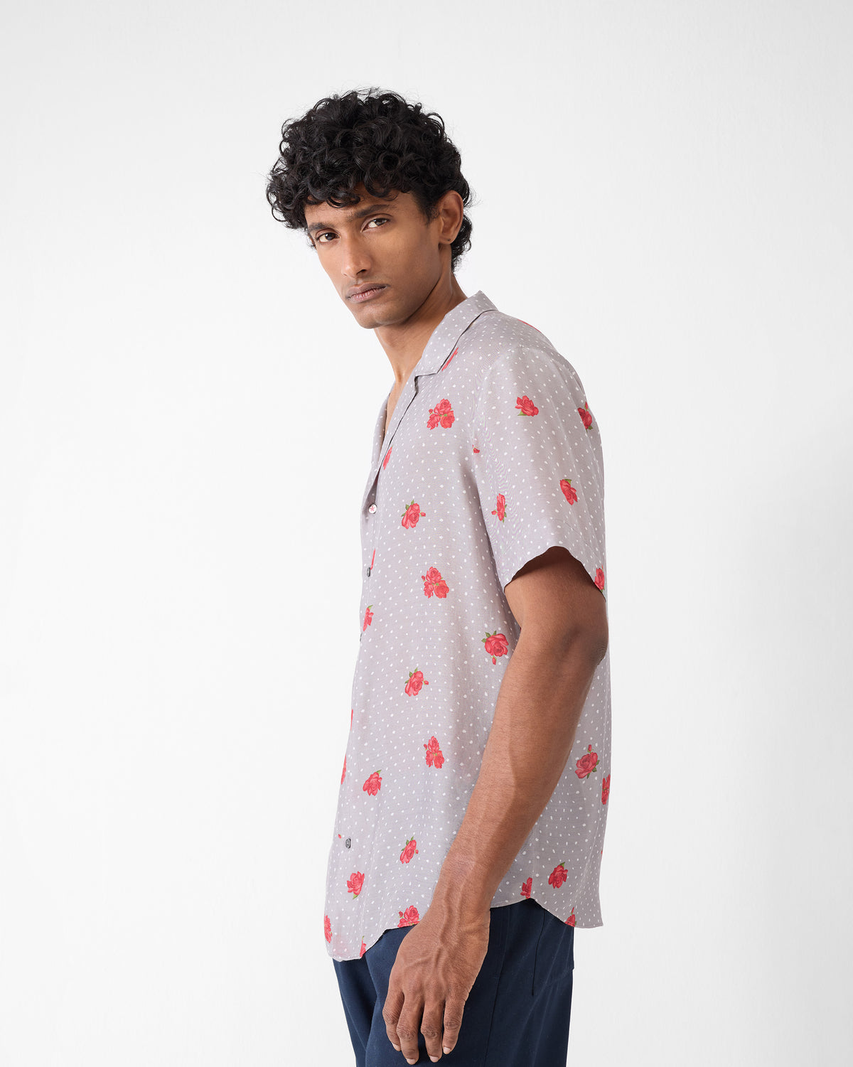 Side view of a charcoal Mistari Shirt with red roses and white dots.